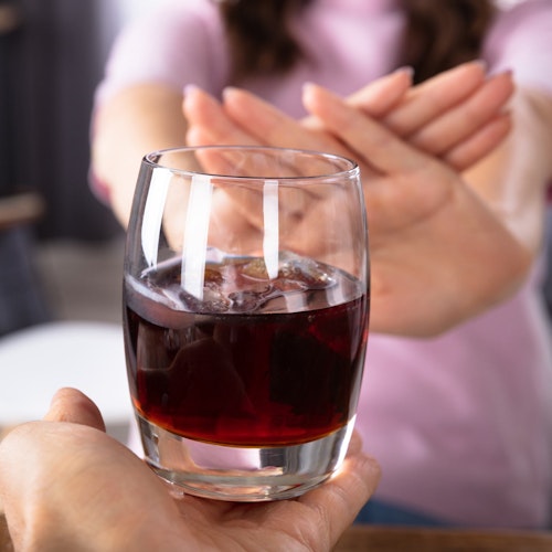 Woman rejecting a glass of wine
