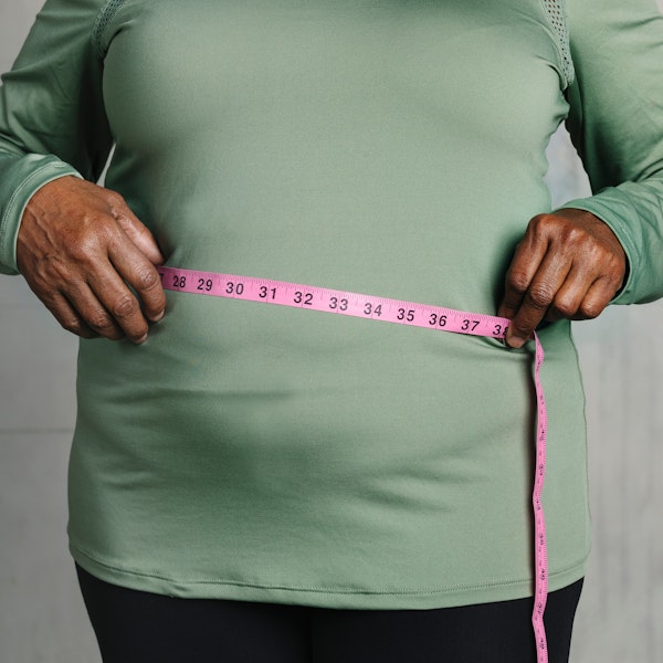 Obese person measuring their waist