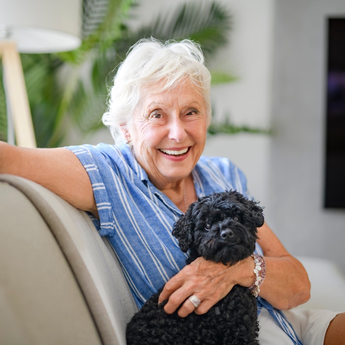 Smiling older woman with dog after dental treatment