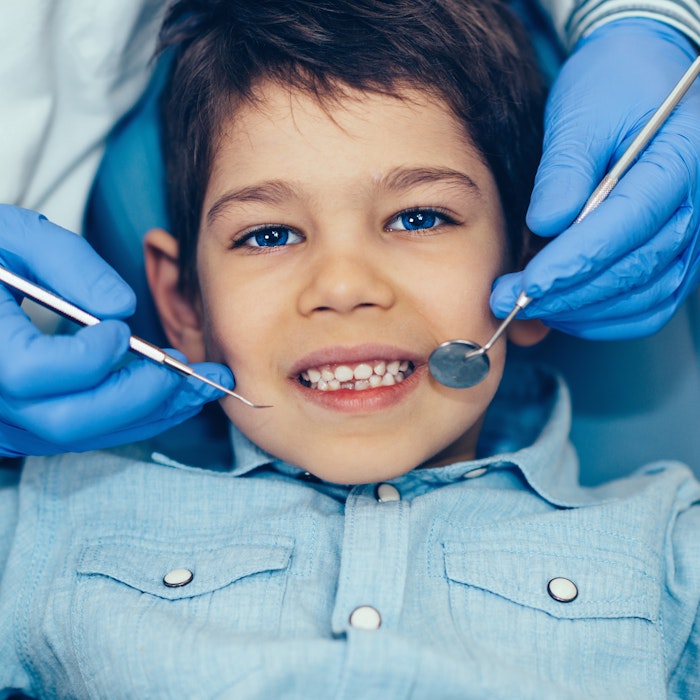 Smiling young boy getting dental exam