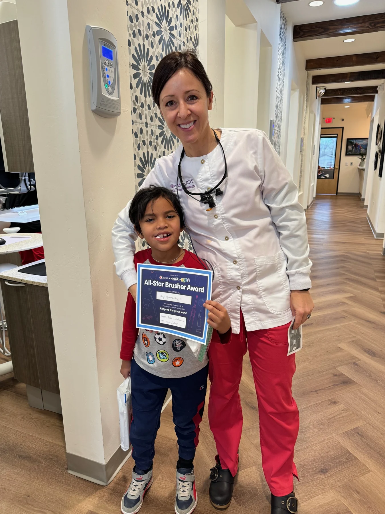 Dr. Adams standing with a young patient in the office
