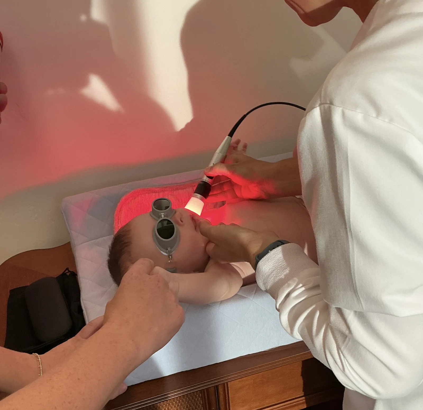 Red-light therapy being provided to an infant at Peak Family Dentistry